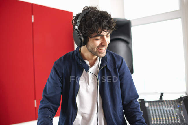 Jovem estudante de DJ universitário masculino ouvindo música em fones de ouvido — Fotografia de Stock