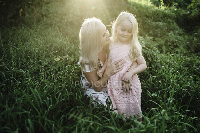Mãe e filha na grama alta — Fotografia de Stock