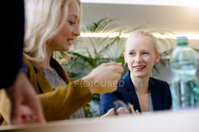 Jóvenes empresarias discutiendo en la mesa de juntas - foto de stock