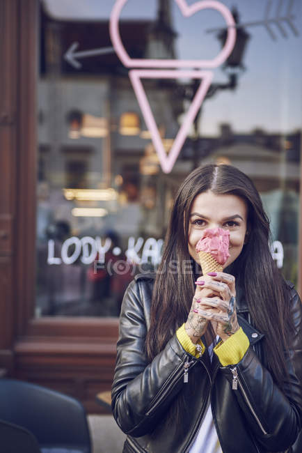 Portrait of young woman holding ice cream, tattoos on hand — Stock Photo