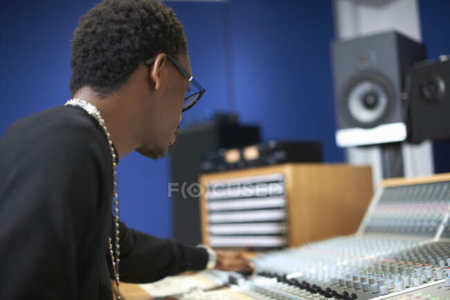 Jeune étudiant masculin au mixeur dans un studio d'enregistrement — Photo de stock