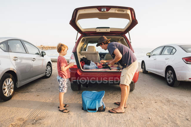 Father and son taking fishing rods from car boot, Goleta, California, United States, North America — Stock Photo
