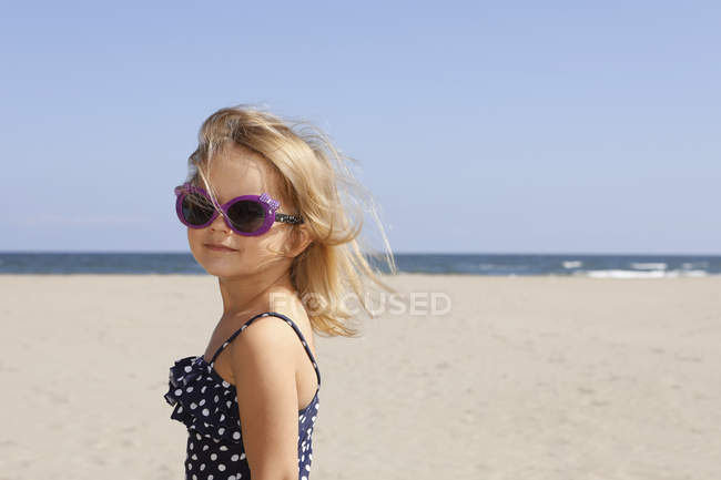 Ritratto di ragazza sulla spiaggia in costume da bagno e occhiali da sole — Foto stock