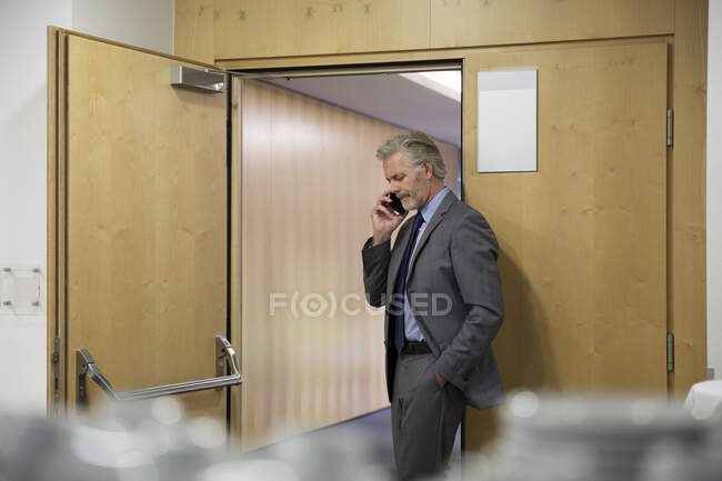 Businessman using smartphone in office — Stock Photo