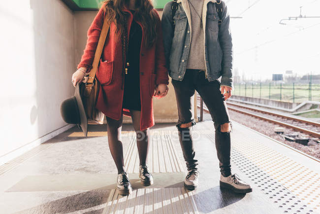 Портрет молодой пары на железнодорожной платформе, низкая секция — стоковое фото