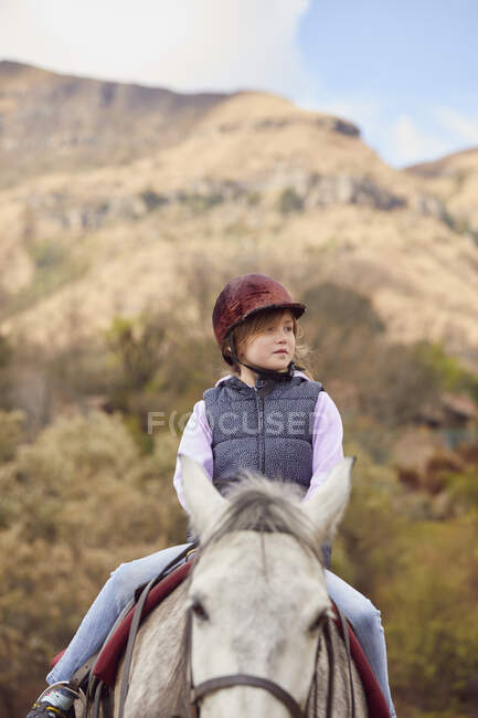 Girl riding horse in rural setting — Stock Photo