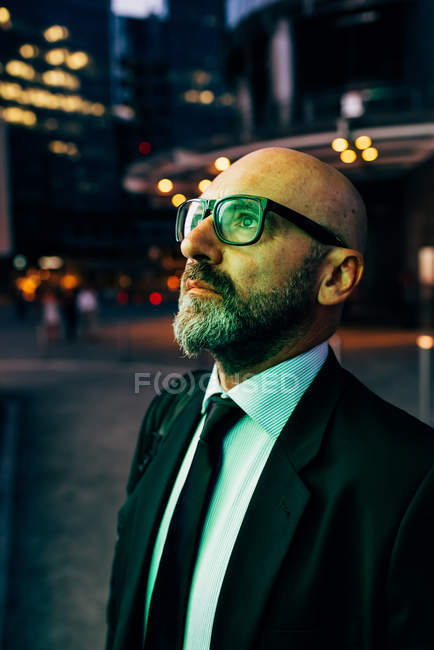 Maturo uomo d'affari guardando fino all'aperto di notte — Foto stock