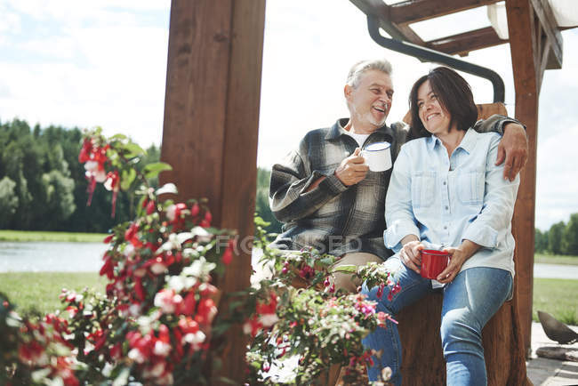 Älteres Paar hält Tassen im Freien — Stockfoto