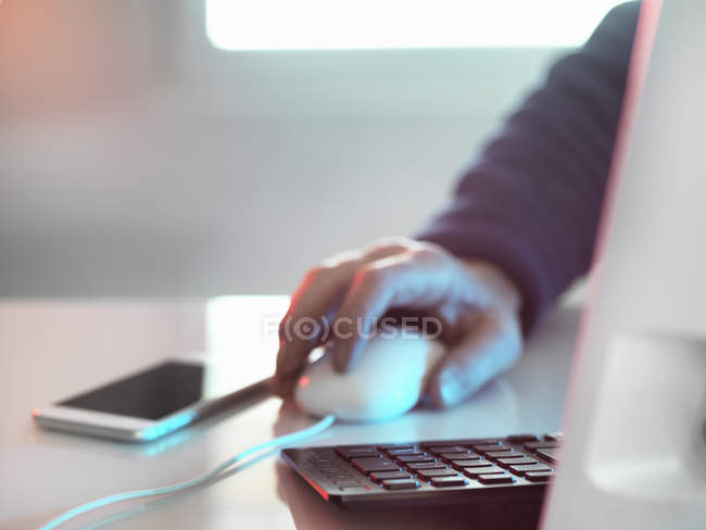 Abgeschnittenes Bild des Menschen am Computer, Smartphone auf der Tischplatte — Stockfoto