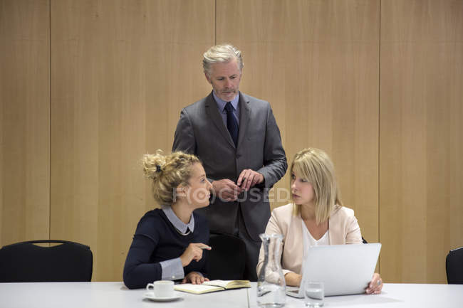 Colleagues using laptop in conference room — Stock Photo