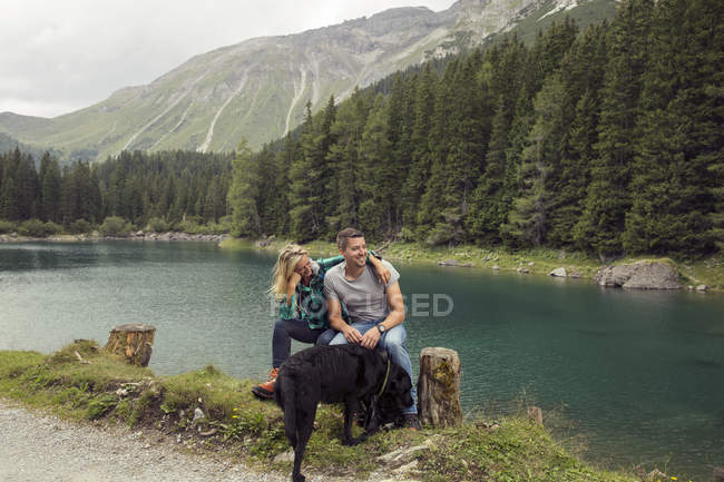 Couple with dog, hiking, sitting by lake, Tirol, Steiermark, Austria, Europe — Stock Photo
