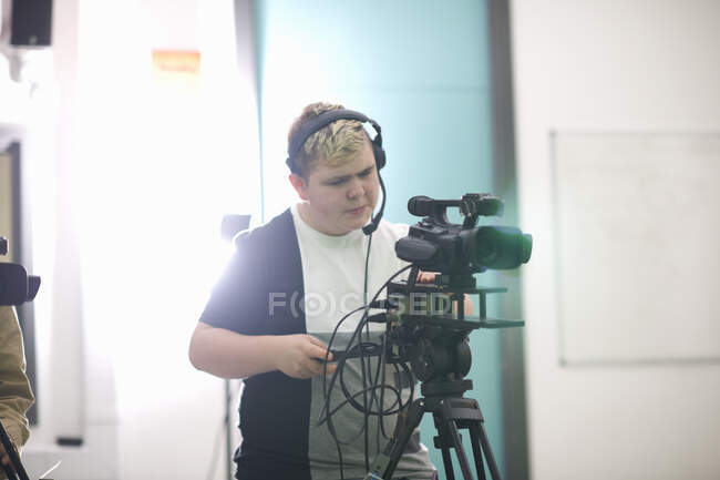 Jeune étudiant masculin filmant dans un studio de télévision — Photo de stock