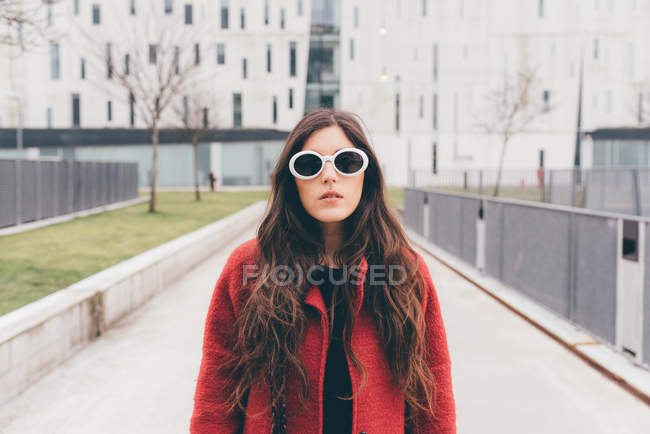 Портрет молодої жінки, в сонцезахисних окулярах, що стоять у міському середовищі — стокове фото