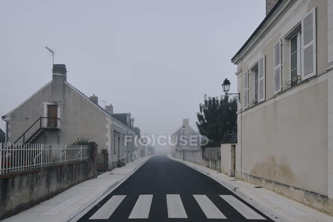 Strada vuota attraverso il villaggio Meigne-le-Vicomte la mattina nebbiosa, Valle della Loira, Francia — Foto stock