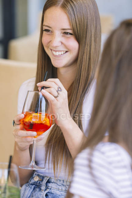 Blick über die Schulter von zwei jungen Freundinnen, die Cocktails in einem Straßencafé trinken — Stockfoto