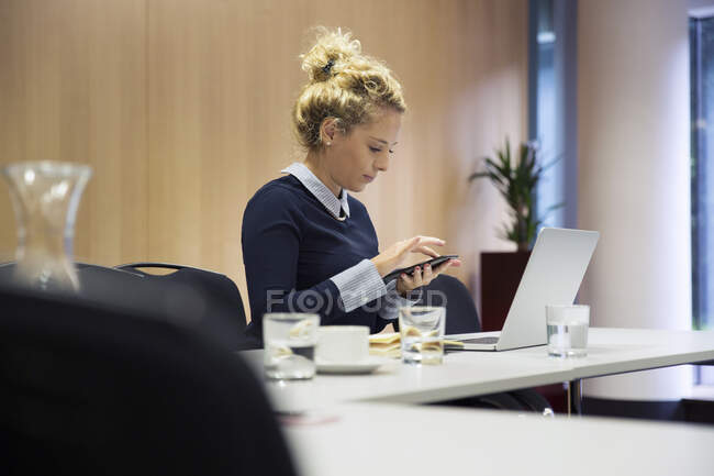 Frau im Büro schreibt SMS auf Smartphone — Stockfoto