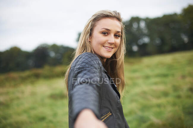 Prospettiva personale della giovane donna che conduce a mano nel campo — Foto stock