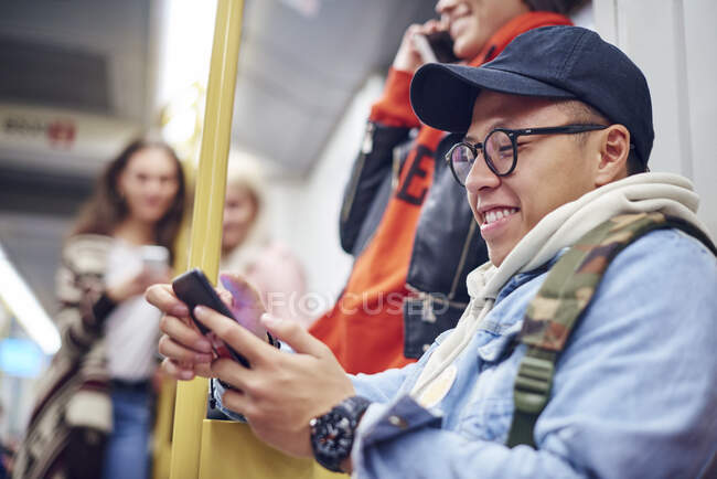 Giovane che guarda smartphone sul tram della città — Foto stock