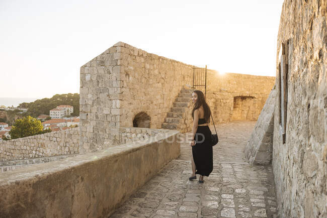 Jovem mulher caminhando ao longo das muralhas da cidade, Dubrovnik, Croácia — Fotografia de Stock