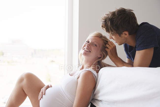 Romantic pregnant couple resting in bedroom — Stock Photo