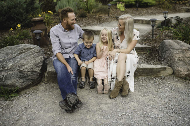 Familie sitzt zusammen auf Stufe — Stockfoto