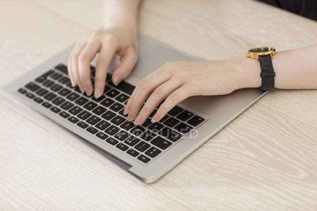 Mujer escribiendo en el teclado del ordenador portátil - foto de stock