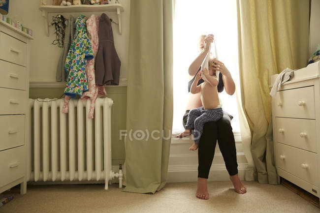 Беременная женщина и дочка в спальне — стоковое фото