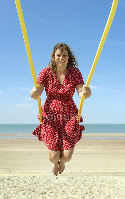 Donna in abito rosso oscillante sulla spiaggia, Zoutelande, Zelanda, Paesi Bassi, Europa — Foto stock