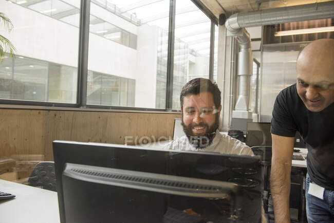 Колеги в офісі дивляться на монітор комп'ютера — стокове фото