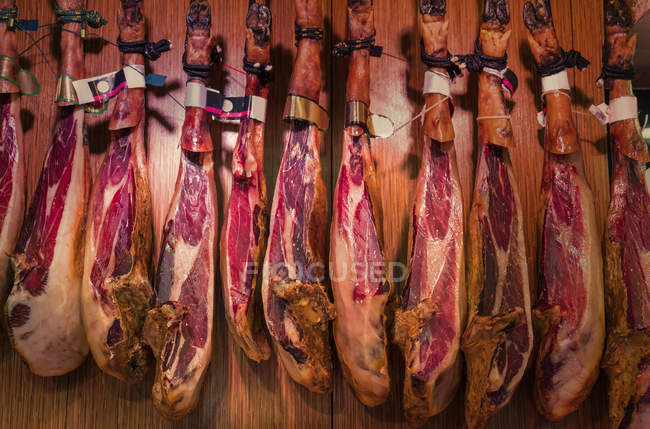 Испанская вяленая ветчина висит на рынке Бокерия, Барселона, Каталония, Испания, Европа — стоковое фото