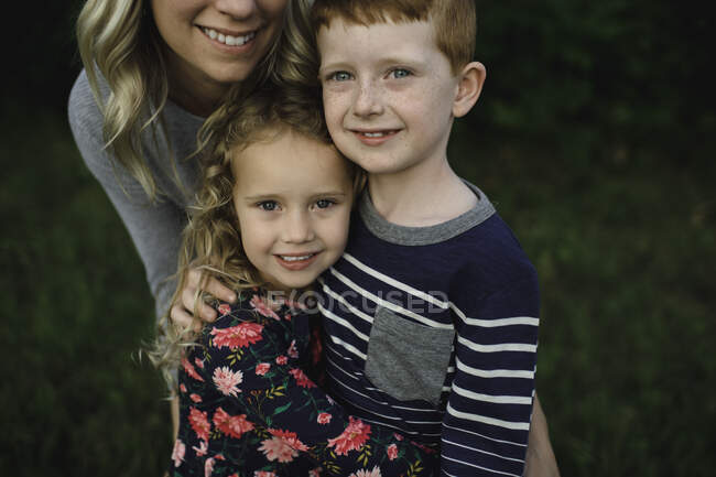 Porträt von Mädchen, Bruder und Mutter, die sich umarmen — Stockfoto