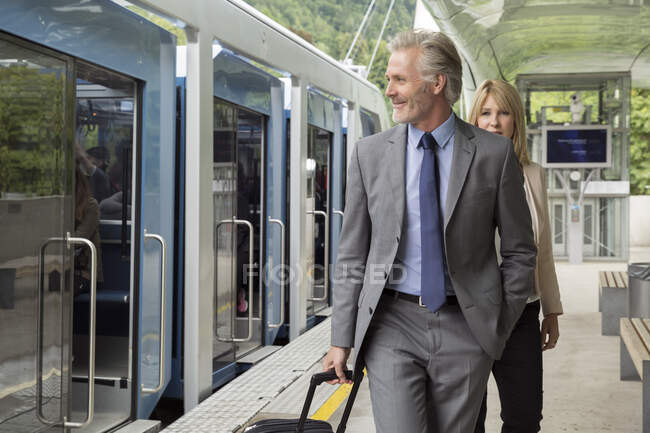 Бизнесмен с чемоданом на железнодорожной платформе — стоковое фото
