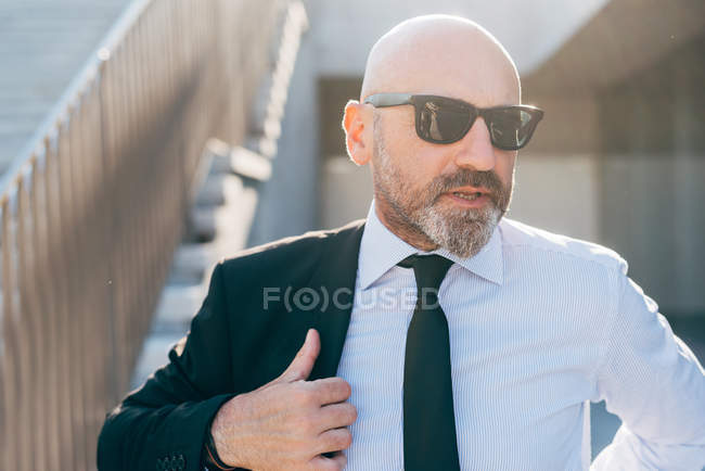 Mature businessman putting suit jacket on — Stock Photo