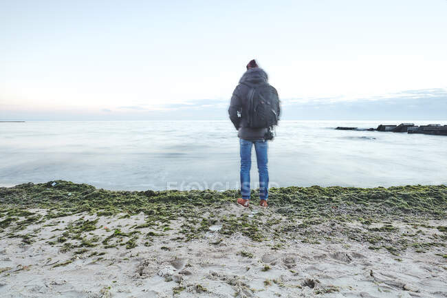 Rear view of man on beach looking away at view of sea, Odessa, Odessa Oblast, Ukraine, Europe — Stock Photo