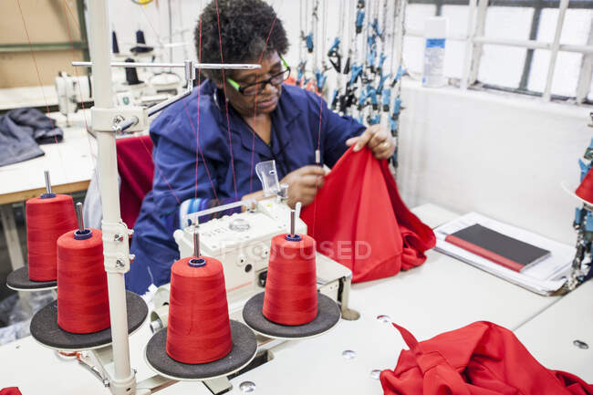 Seamstress работает над оверлокером на заводе, Кейптаун, Южная Африка — стоковое фото