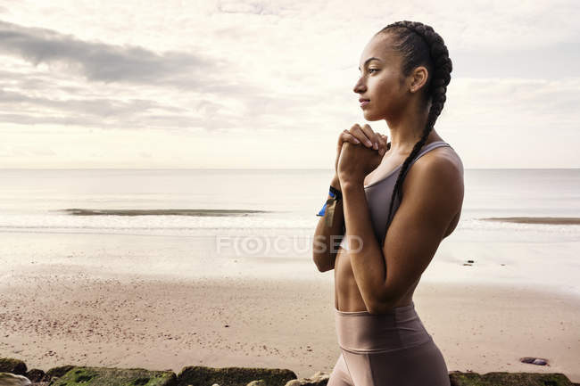 Молода жінка бігун готується до запуску на пляжі — стокове фото
