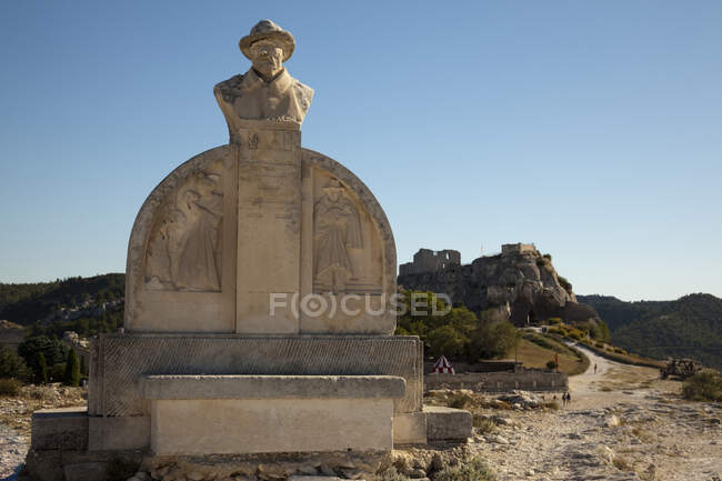 Denkmal von Charloun Rieu und Blick auf entfernte Stadt und Schloss, Les Baux-de-Provence, Provence-Alpes-C? te d 'Azur, Frankreich — Stockfoto
