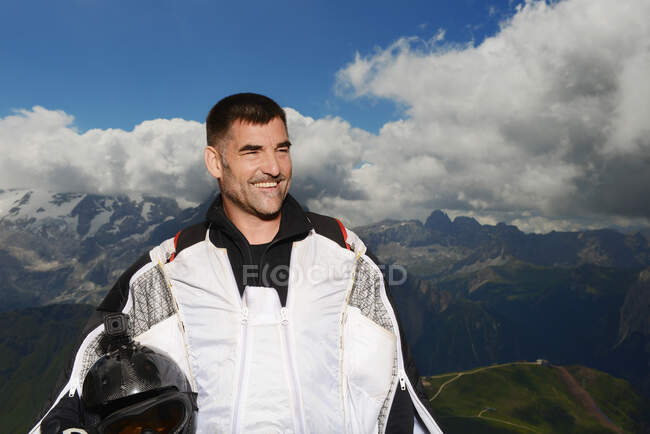 Portrait of base jumper wearing wingsuit looking away smiling, Dolomite mountains, Canazei, Trentino Alto Adige, Italy, Europe — Stock Photo