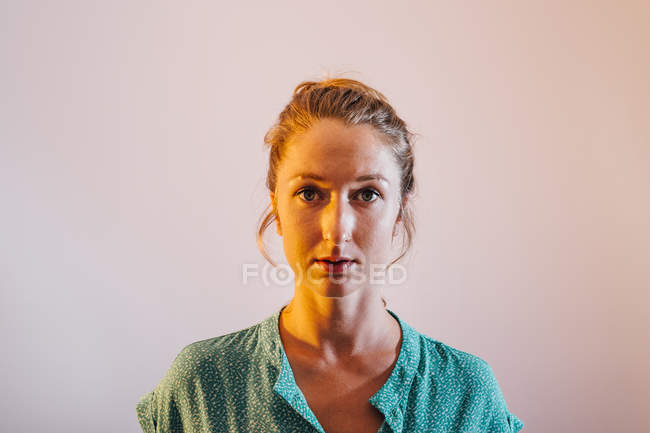 Portrait of young woman against pink background — Stock Photo