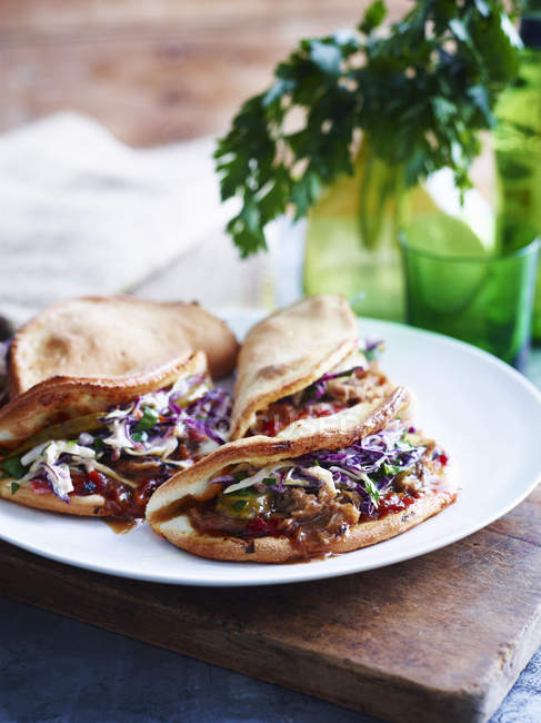 Pulled pork, coleslaw and pickle folded pizza on white plate, close-up — Stock Photo