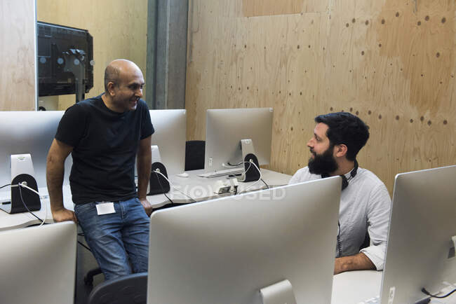 Колеги спілкуються в комп'ютерній кімнаті — стокове фото