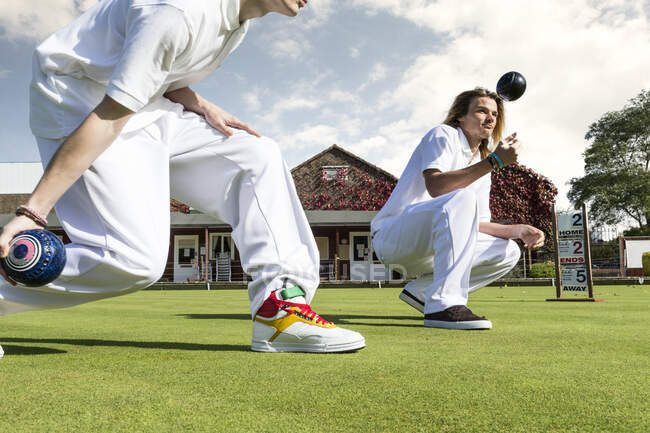 Colpo ritagliato di due giovani uomini prato bowling su bowling verde — Foto stock