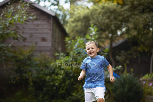 Menino correndo no jardim — Fotografia de Stock