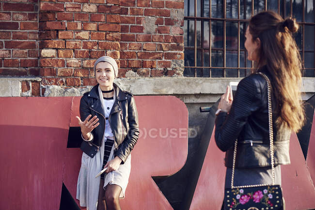 Two young female friends talking on city street — Stock Photo