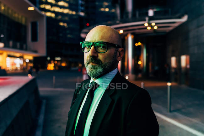 Portrait of mature businessman outdoors at night — Stock Photo