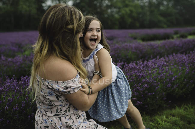 Мати і дочка грають у лавандовому полі — стокове фото