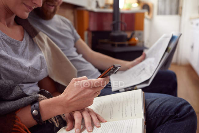 Pareja leyendo juntos en casa - foto de stock