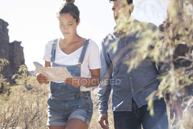 Young hiking couple looking at map in valley, Las Palmas, Canary Islands, Spain — Stock Photo