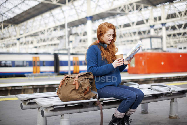 Жінка на лавці на платформі вокзалу — стокове фото