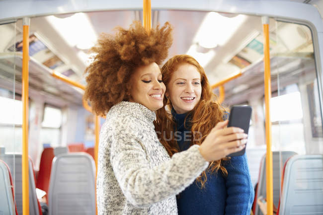 Друзі беруть селфі з мобільним телефоном на поїзді — стокове фото